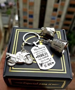 Foto real: llavero de 3 dijes con moto, casco y campana biker grabados, sobre su caja de regalo - Jefer Store